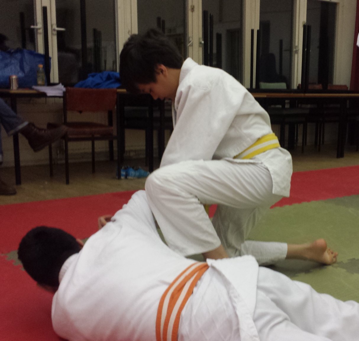 Junior student performing a ground restraint on a downed opponent