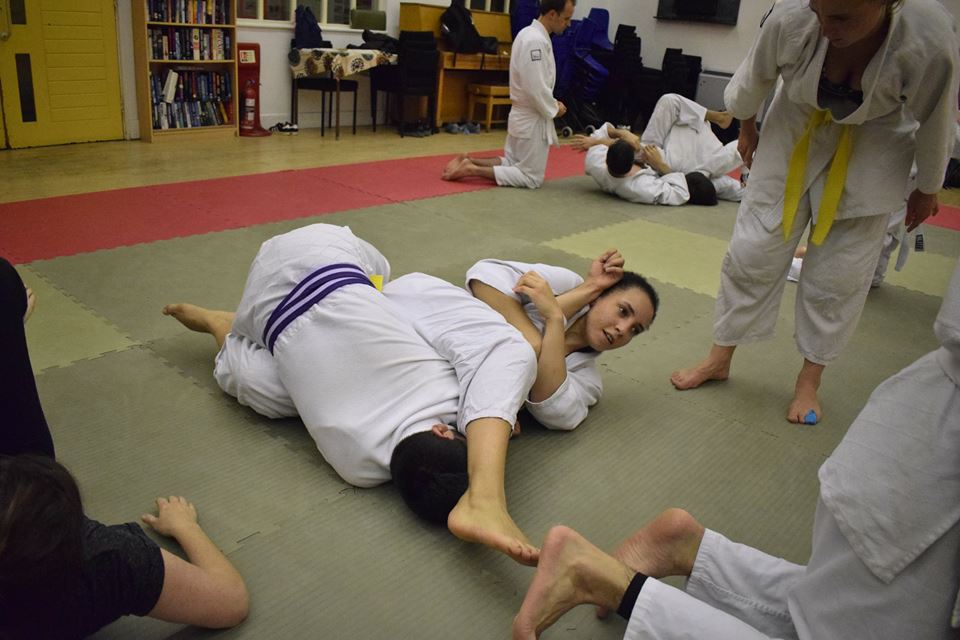 A student performs an armbar on a downed opponent