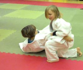 Junior student performing a ground restraint on a downed opponent
